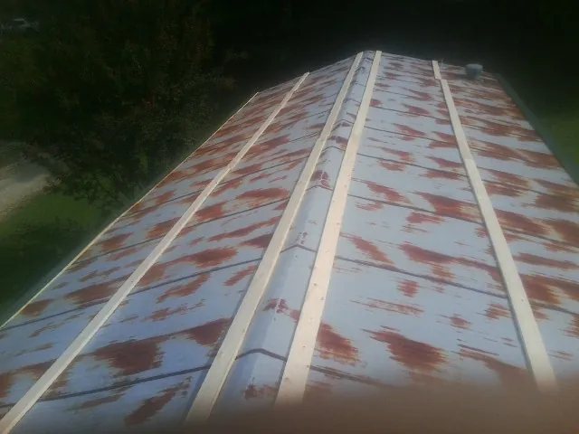Rusted metal roof panels with new wood purlins before replacement — Storm Damage Roof Repair in Stockport by Roofing Brothers